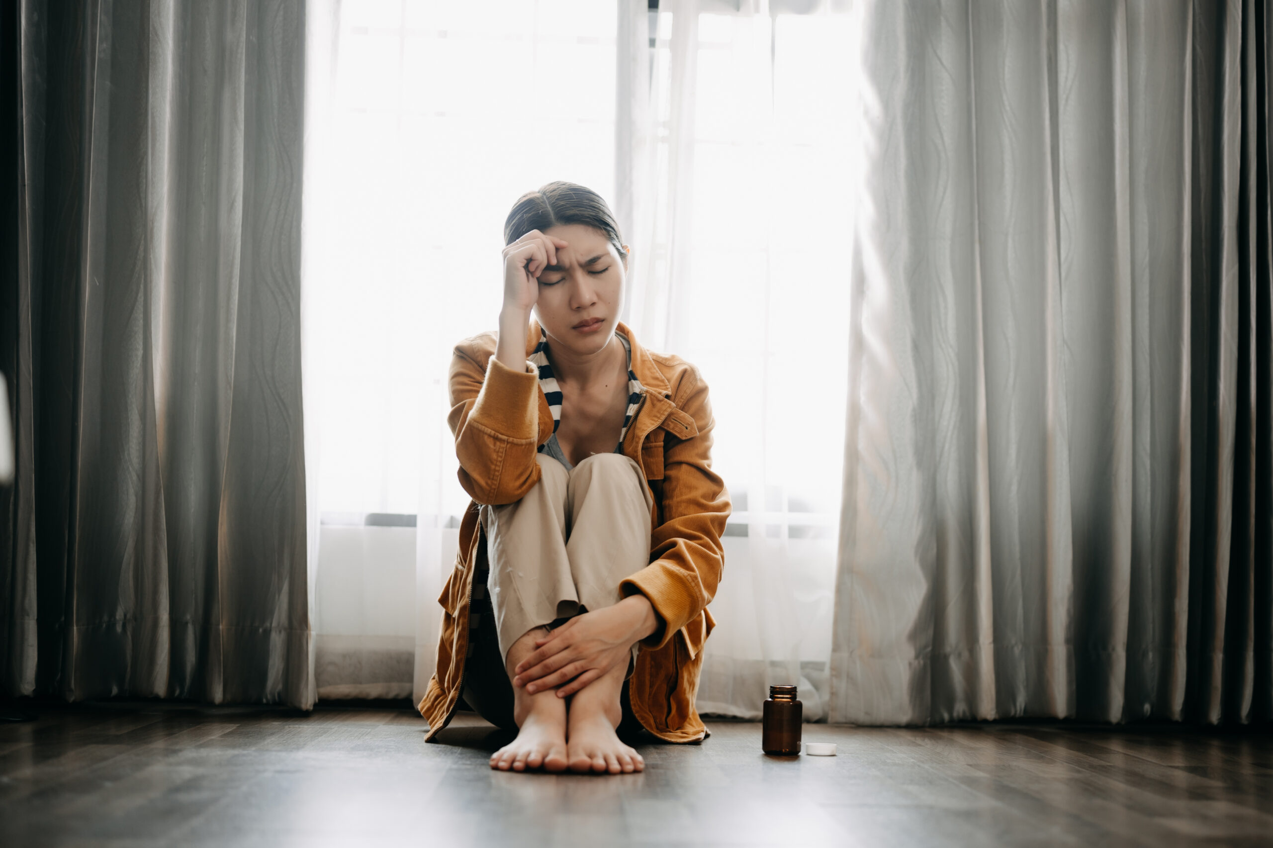 Woman sat on the floor, head in hands