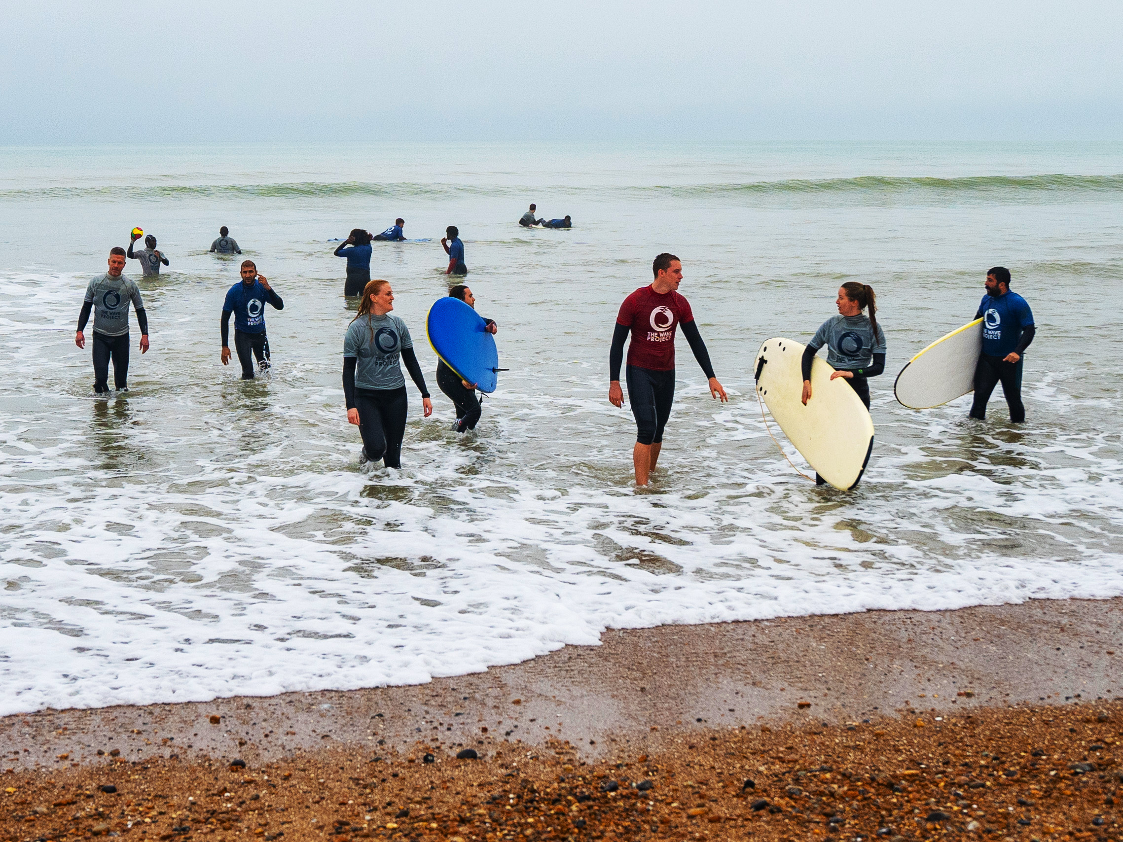 Surfers from the Wave project coming out of the sea