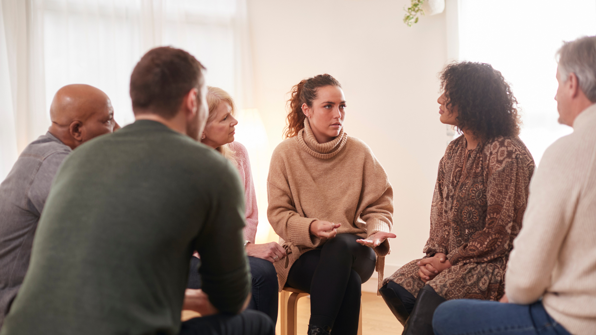 A group of parents sit talking without their children present.